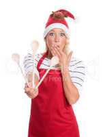 Frau mit Weihnachtsmütze hält Kochlöffel und ist erstaunt