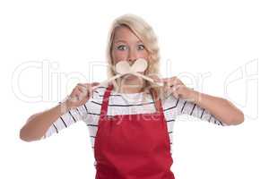 Hausfrau hält sich Kochlöffel vor den Mund