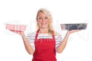 Hausfrau in Küchenschürze zeigt verschiedene Backformen