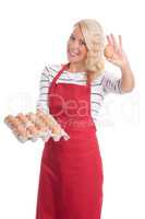 Hausfrau in Schürze hält eine Palette Eier