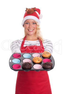 Frau mit Weihnachtsmütze bietet selbstgebackene Muffins an