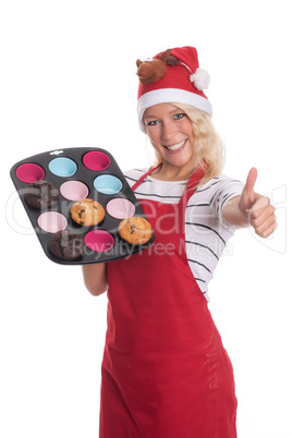 Weihnachtsfrau hat Muffins gebacken und zeigt Daumen hoch