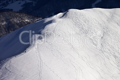 Top view on off piste slope with snowboarders and skiers in even