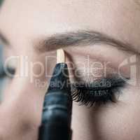 Close Up of Woman Applying Make Up Along Brow Line