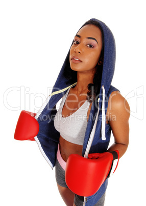 Athletic woman in hoody wearing boxing gloves.