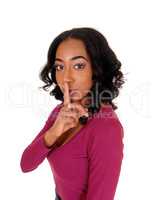 African woman with finger over mouth.