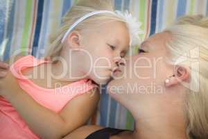 Little Girl Laying on Blanket Kisses Her Mommy