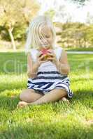 Little Girl Sitting and Eating Apple Outside