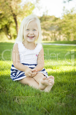 Cute Little Girl Sitting and Laughing in the Grass