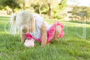 Little Girl Having Fun with Her Piggy Bank Outside