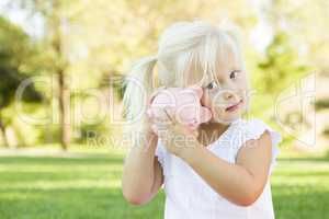 Little Girl Having Fun with Her Piggy Bank Outside