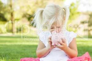 Little Girl Having Fun with Her Piggy Bank Outside