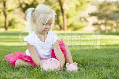 Little Girl Having Fun with Her Piggy Banks Outside