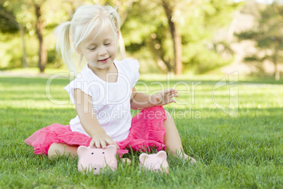 Little Girl Having Fun with Her Piggy Banks Outside