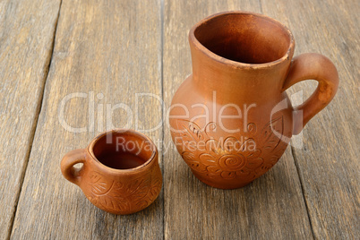 crock and a cup on a wooden surface