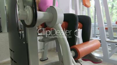 Seated leg extension machine exercise in health fitness club