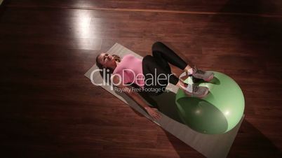 Fit girl exercising at fitness club with stability ball for core training