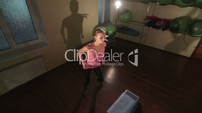 High-angle shot of fit woman doing step aerobics exercise in fitness club