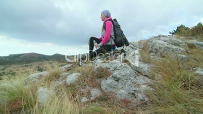 JIB CRANE: Young woman hiking on mountain plateau drinking water