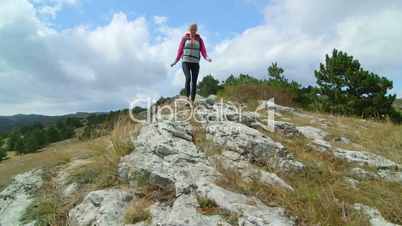 JIB CRANE: Woman day hiking highlands walking along bare stone plateau