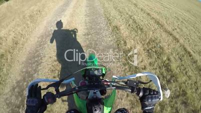 Point of View: Enduro biker riding motorcycle on dirt track