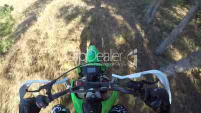 Point of View: Enduro racer on dirt bike riding off-road through the forest