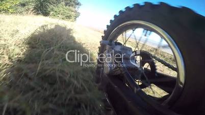 Offroad bike riding on dirt track rear wheel point of view