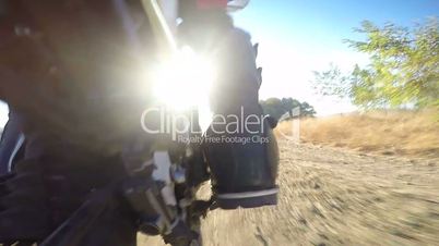 Enduro racer riding bike on dirt track rear wheel point of view