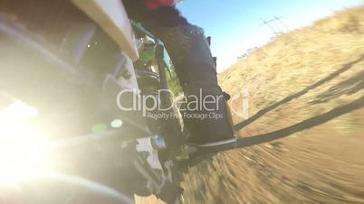 Enduro racer riding bike on dirt track rear wheel point of view