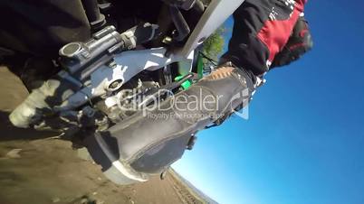 Enduro racer riding bike on dirt track rear wheel point of view