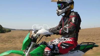 Enduro racer riding his offroad bike on road