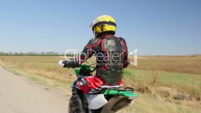 Enduro racer in motorcycle protective gear riding bike