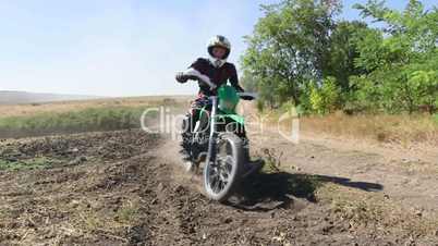 Motocross racer riding his dirt bike kicking up dust jib crane shot