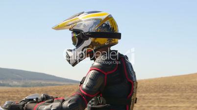 Enduro racer in motorcycle protective gear riding dirt bike closeup