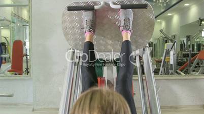Young woman training in health fitness club on leg press machine