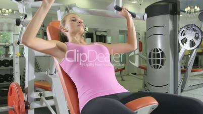 Young woman training in free weights area at health fitness club
