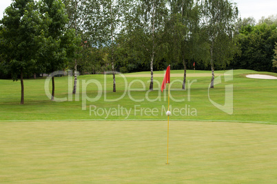 Red flag on a golf course, focus on the flag