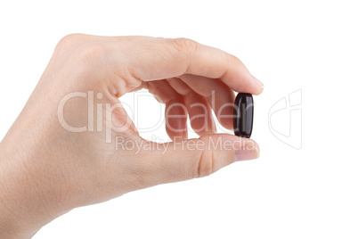 Woman's hand holding black pill