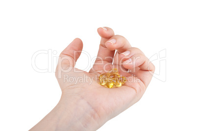 Cod liver oil pills in hand on white