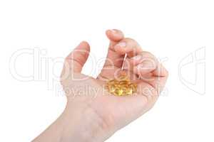 Cod liver oil pills in hand on white