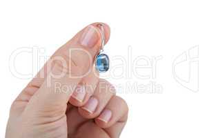 Female hand holding a sapphire earring