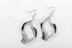 Pair of silver earrings on white background