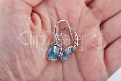 Pair of sapphire earrings in the palm of a female hand