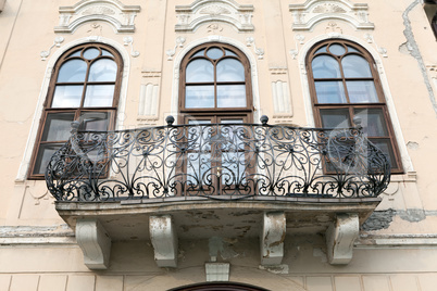 Balcony on a castle with three windows and the wrought iron bani