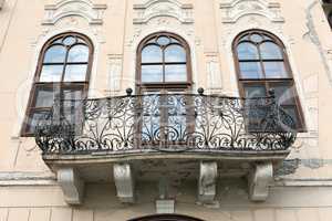 Balcony on a castle with three windows and the wrought iron bani