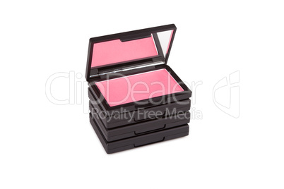 Pink blush on a pile of blush boxes isolated on white