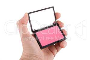 Female hand holding a pink blush, isolated on white