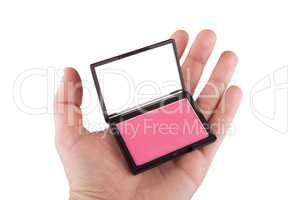 Female hand holding a pink blush, isolated on white