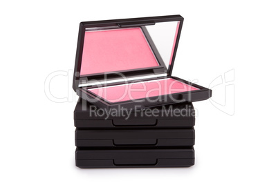 Pink blush on a pile of blush boxes isolated on white