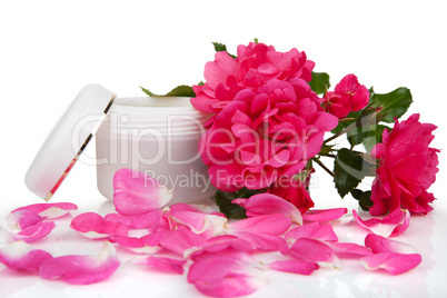 Open jar with the cosmetic cream and rose petals
